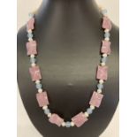 A 22" fresh water pearl necklace with pink and square shaped blue jade beads & gold tone hook clasp.