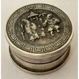 A Chinese white metal rouge pot with figural detail to lid and Greek key design to rim.