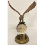 An ornamental brass ball clock with eagle shaped finial and rabbit figures to base.