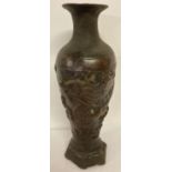 A Chinese bronze vase with dragon design and hexagonal shaped metal base.