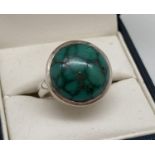 A modern design silver dress ring set with a round cabochon of green turquoise. Inside of band