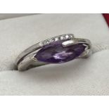 A modern contemporary style 9ct white gold dress ring set with amethyst & diamonds. A double band
