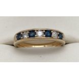 An 18ct gold channel style set sapphire and diamond half eternity ring. 4 round cut sapphires