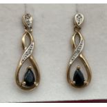 A pair of 9ct gold, diamond and black onyx twist design drop earrings. Complete with butterfly