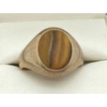 A men's 9ct gold signet ring set with a oval shaped Tigers Eye stone. Total weight approx. 4.4g.