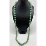 A 35" Chinese jade beaded necklace, knotted between each bead. Beads approx. 1cm diameter.