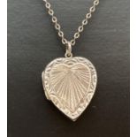 A vintage silver heart shaped locket with floral and sunray decoration, on a 16" fine belcher