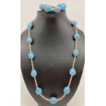 A 24" necklace and matching bracelet made with pale blue Venetian style glass beads. Necklace has