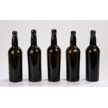 Five George III period brown glass bottles, 19th Century, with ring tops above the cylinder