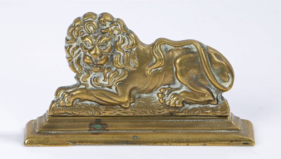 Brass recumbent lion door stop, 18cm wide, 10cm high