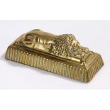Brass sleeping lion door stop, on a weighted gadrooned plinth base, 22cm wide, 9cm high