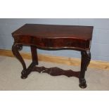 Victorian mahogany console table, with a serpentine top above lion paw feet, 107cm wide