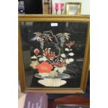 Needlework picture depicting a vase of flowers on a black background, housed in a gilt glazed frame,