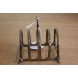 George V silver toast rack, Birmingham 1927, maker Walker & Hall, with pierced finial above four