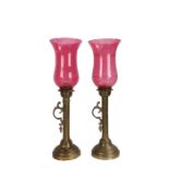 Pair of brass storm lanterns, with cranberry glass shades, 46cm high