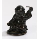 Chinese bronze figure depicting a baby holding a stick to each hand, 9cm high