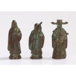 Three Oriental cast metal figures, to include figure holding a stick and orb, 8.5cm high (3)