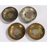 Set of four silver plated and brass Middle Eastern dishes, with coin inset bases and foliate