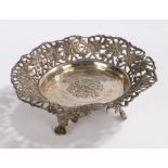 Eastern white metal dish, wih pierced foliate border, raised on three scroll cast feet, 13.5cm