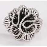 18 carat white gold diamond set ring, with a high scrolling diamond set head, the diamonds at a