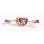 Ruby and diamond set heart brooch, with interwoven hearts to the bar flanked by a ruby to each