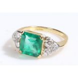 Emerald and diamond set ring, the central emerald at 2.50 carats three three diamonds to either