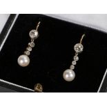 Pair of diamond and pearl set earrings, with a row of diamonds above the pearl drops, a total