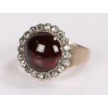 Garnet and diamond set ring, the cabochon cut garnet with a diamond set surround, ring size M