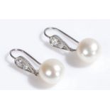 Pair of diamond and pearl set earrings with diamonds to the pear drops above the pearls, 25mm long
