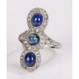 Sapphire and diamond set ring, with three cabouchon cut sapphires to the centre at 3.69 carats and