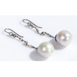Pair of diamond and pearl set earrings, with diamonds set to the stem above the drop pearl, 50mm