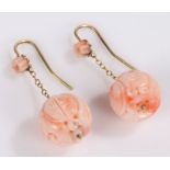 Pair of coral earrings, the Chinese coral carved with medallions and beasts, 12mm diameter