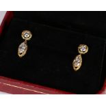 Pair of diamond set earrings, the round cut diamond above the navette cut diamond set within gold