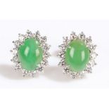 Pair of jade and diamond set earrings, the studs with a cabochon jade and diamond surround