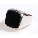 White metal signet ring, of large size, having an inset black stone to the head, ring size T