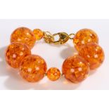 Copal amber effect bead bracelet, with gilt heart decorated clasp