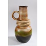 Substantial West German vase, with loop handle above a ridged body decorated in browns, greens and