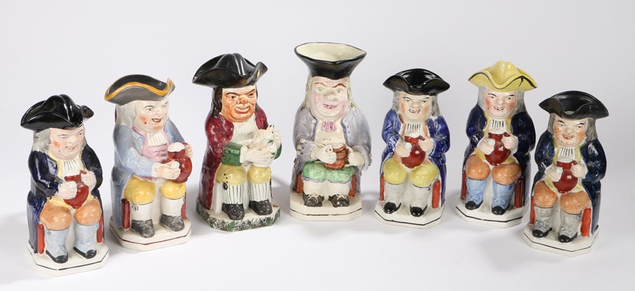 Collection of seven 19th Century Toby Jugs, all in a seated position holding jugs of beer, three
