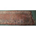 Middle Eastern runner, the red ground with lozenge pattern centre and multiple borders, 370cm x