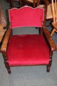 Edwardian oak bedroom chair, the arched red upholstered back flanked by shaped arms and red