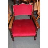 Edwardian oak bedroom chair, the arched red upholstered back flanked by shaped arms and red