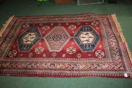 Two Belgian rugs, the red ground with lozenge pattern centres and tasseled ends, 198cm x 138cm,