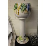 Portugese pottery jardeniere on stand, with green and yellow painted decoration on white ground 76cm