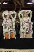 Pair of porcelain figures, depicting a man and a woman sitting down on two chairs, 15cm high (2)