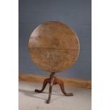 George III oak occasional table, the circular tilt top with turned baluster column and raised on