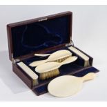 Edwardian ivory dressing table set, with brushes and mirror housed within a fitted leather box, 37.
