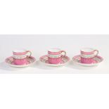 Three Victorian porcelain cup and saucers, decorated with bands of flowers with gilt borders on a