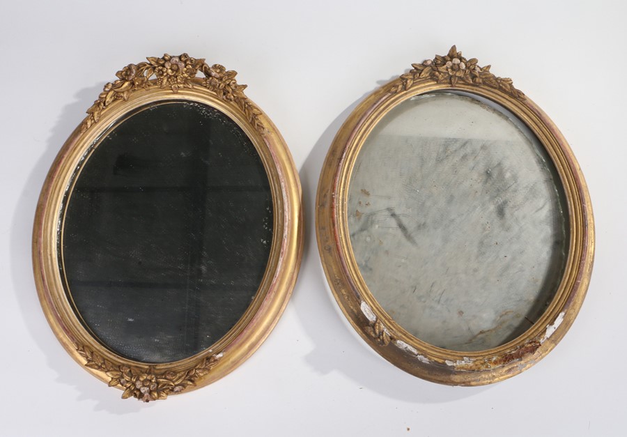 Two 19th Century oval framed mirrors, each housed within gilt frames and mounted with floral