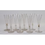Eight Victorian glass champagne flutes, of typical tapering form and circular foot, the tallest 18cm