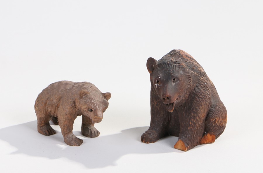 Two Black Forest carved wooden bears, one modelled in a seated position (AF), (2)